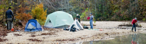 group of people camping on a river bank