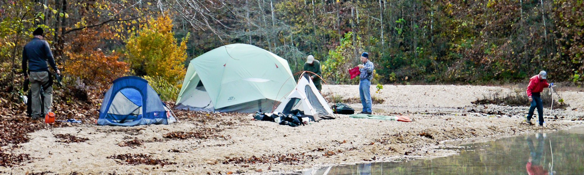 sharing-the-ozark-trail. group of people camping on a river bank. 